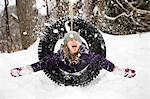 Girl playing in snow on tire swing