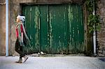 Side view of woman walking in street. Bruniquel, France