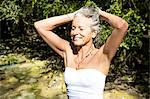 Woman wearing swimsuit tying hair