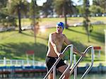 Swimmer coming up from water on ladder, Eastern Beach, Geelong, Victoria, Australia