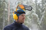 Logger wearing safety visor in forest, Tammela, Forssa, Finland