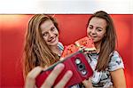 Teenage girls taking selfie and eating watermelon