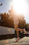 Teenage girl jumping in street, Cape Town, South Africa