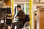 Woman in wheelchair in bicycle repair shop