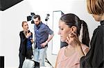 Make up artist applying blusher to fashion model in photography studio