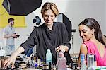 Fashion model and make up artist getting ready in photography studio