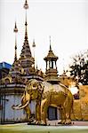 Golden elephant statue and spires of buddhist temple, Chiang Mai, Thailand