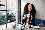 Mid adult woman holding coffee cup in cafe