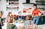 Florist teaching students in flower arranging workshop