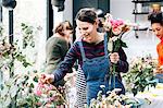 Florist student selecting cut flowers at flower arranging workshop