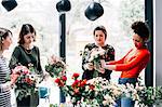 Florist and students arranging bouquets at flower arranging workshop