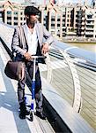 Businessman with scooter, Millennium Bridge, London, UK