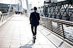 Businessman on scooter, Hungerford Bridge, London, UK