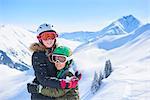 Portrait of skiing teenage girl and brother hugging in Swiss Alps, Gstaad, Switzerland