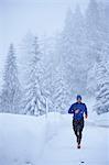 Male runner running in falling snow, Gstaad, Switzerland