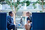 Businesswoman and man at meeting in office atrium