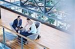 High angle view of businessmen and businesswoman meeting on office balcony