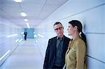 Businesswoman and man talking in office corridor