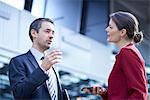 Businessman and woman talking in office atrium