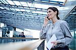 Businesswoman making smartphone call on office balcony