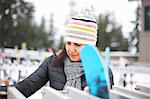 Woman selecting ski equipment, Vancouver, Canada