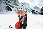 Hiker snow covered landscape preparing hiking equipment, Lake Louise, Canada