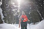 Hiker hiking in snow covered forest, Lake Louise, Canada