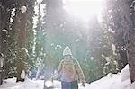 Hiker hiking in snow covered forest, Lake Louise, Canada