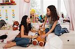 Girls on bed with soft toy talking