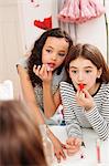 Girls applying makeup in mirror