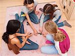 Girls sitting on floor playing dominoes