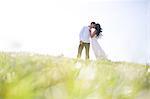 Romantic couple kissing on grassy hill