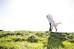 Romantic couple kissing on sunlit grassy hill