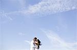 Romantic couple kissing against vast blue sky
