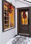 Window and brown front entrance door with Christmas lights and decorations, Quebec, Canada