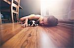 Girl lying on floor with sleeping Boston Terrier puppy