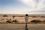 Rear view of woman wearing sunhat looking away at desert, Salton Sea, California, USA