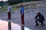 Teenage boys and father by water's edge, Washington, USA