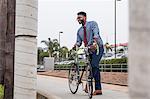 Young businessman cyclist on rail station platform