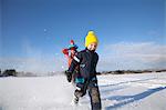 Father and two sons fooling around, running through snow covered landscape