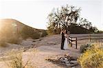 Bride and groom, in arid landscape, standing face to face