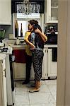 Grandmother hugging granddaughter in kitchen