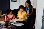 Mother, grandmother and girl looking at photo album