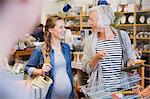 Smiling pregnant woman and mother shopping in shop