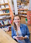 Portrait laughing pregnant woman using cell phone in shop