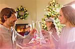 Couple toasting champagne flutes at Christmas dinner table