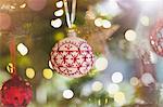 Red and white ornament hanging from Christmas tree