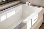 Sunny reflection over modern white bathtub