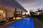 Tranquil blue lap swimming pool outside modern luxury home showcase exterior