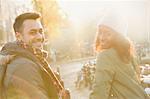 Portrait smiling young couple on sunny urban autumn street